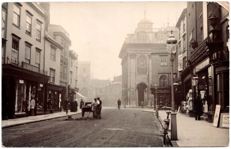 The front of an old postcard. The postcard is of Abingdon: Town Centre Streets