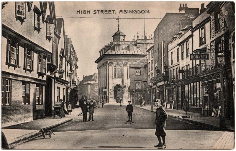 The front of an old postcard. The postcard is of Abingdon: Town Centre Streets