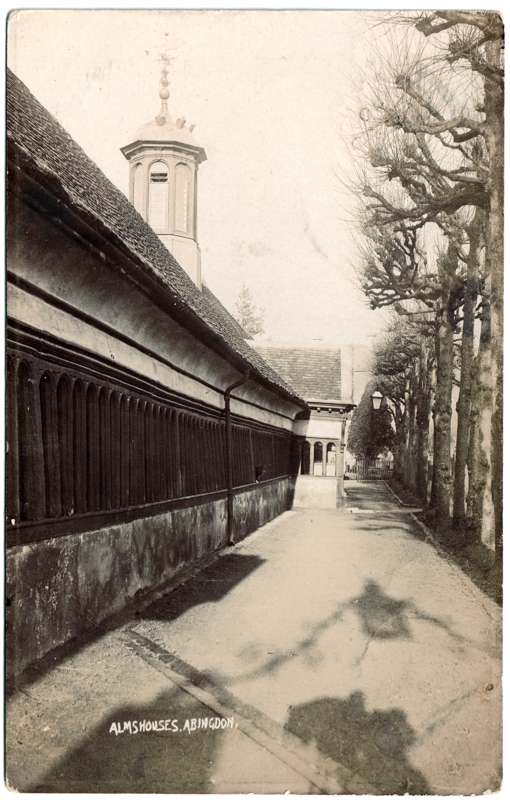 The front of an old postcard. The postcard is of Abingdon: St. Helen's Church and the Almshouses