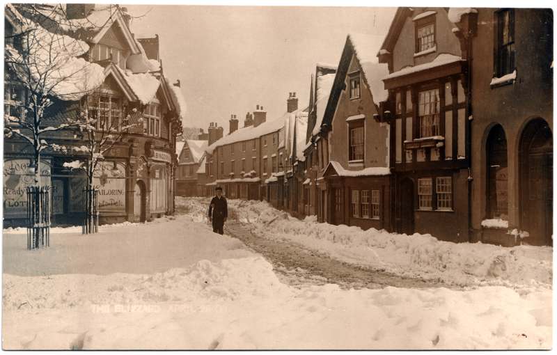 The front of an old postcard. The postcard is of Abingdon: Town Centre Streets