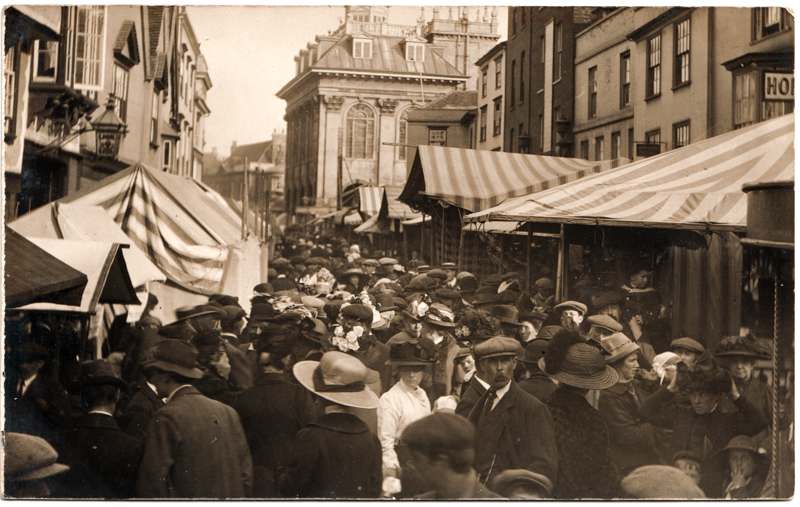 The front of an old postcard. The postcard is of Abingdon: Town Centre Streets