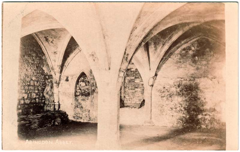 The front of an old postcard. The postcard is of Abingdon: The Abbey Buildings