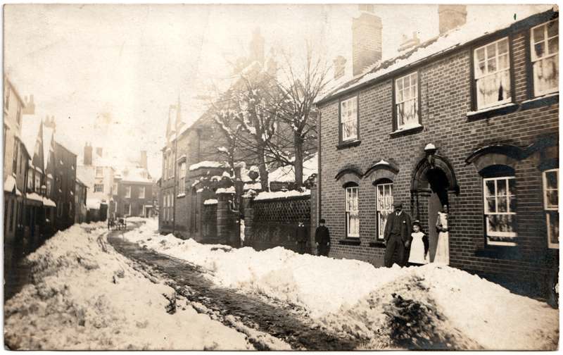 The front of an old postcard. The postcard is of Abingdon: Town Centre Streets